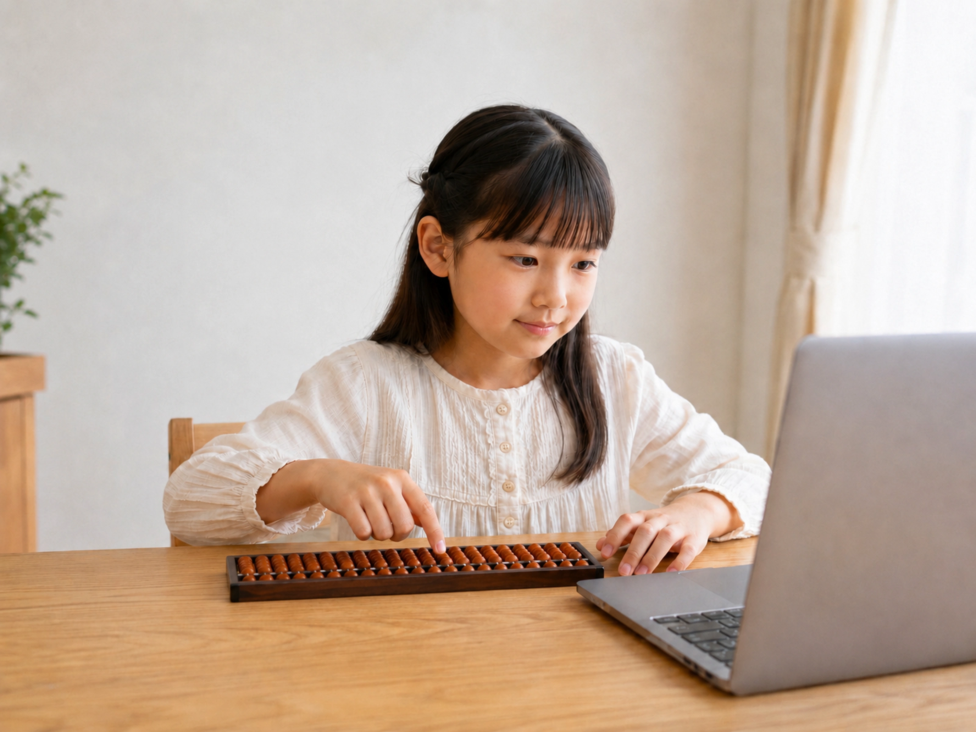 自宅でノートパソコンを見ながら、そろばんを学ぶ小学生の女の子